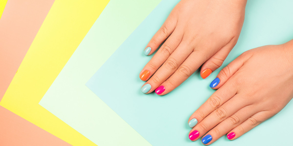 Neon manicure on multicolored bright background in trendy colors.