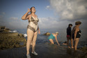 A woman talks to a friend before entering the sea in Havana