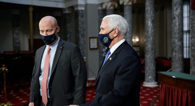 Vice President Mike Pence, joined at left by chief of staff Marc Short, finishes a swearing-in ceremony for senators in the Old Senate Chamber at the Capitol in Washington, Sunday, Jan. 3, 2021.