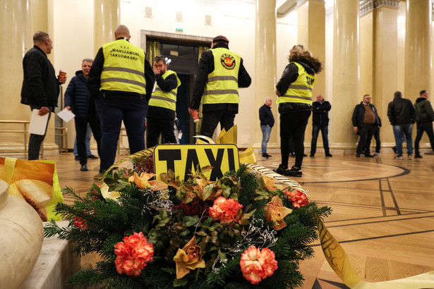 Warszawa, 04.04.2024. Protest taksówkarzy przed sesją rady Warszawy w Stołecznym Pałacu Kultury i Nauki, 4 bm. Taksówkarze od dłuższego czasy apelują o zmianę taryf, argumentując to wzrostem kosztów prowadzenia działalności, wysokimi składkami na ubezpieczenie społeczne oraz rosnącymi kosztami paliwa. Zwracają oni również uwagę na potrzebę podniesienia jakości usług, ze względu na dużą konkurencję kierowców prywatnych firm. (ad) PAP/Paweł Supernak