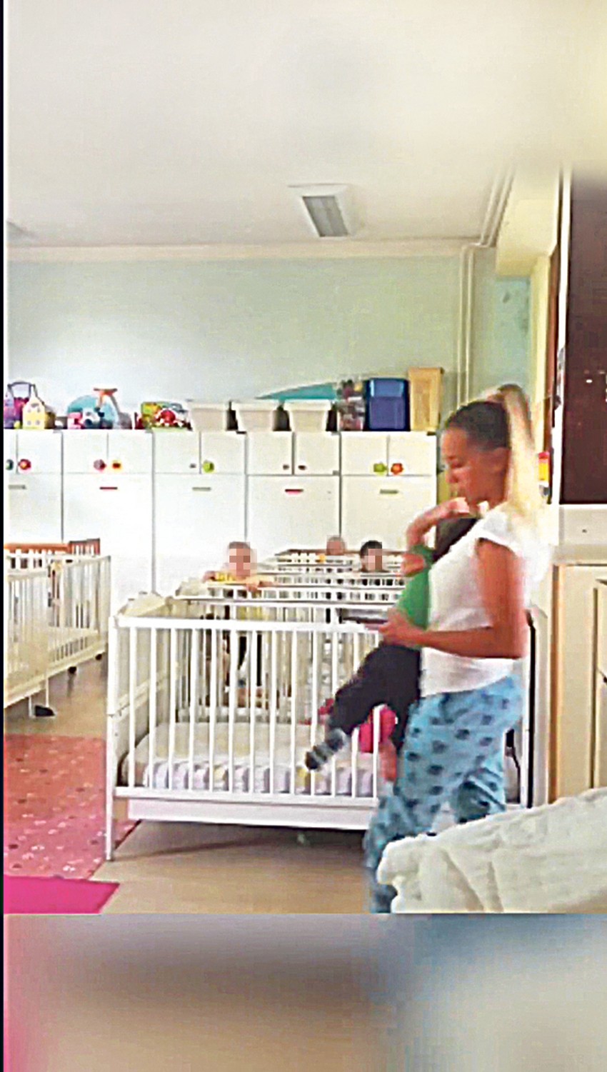 Medicinska sestra ulazi u sobu, a mališana grubo drži jednom rukom