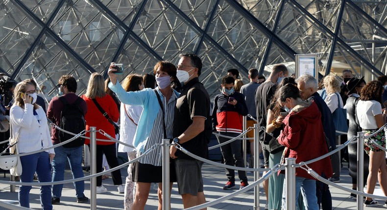 Visitors queue in front of the Louvre during the reopening of the Paris museum after a 4-month closure.