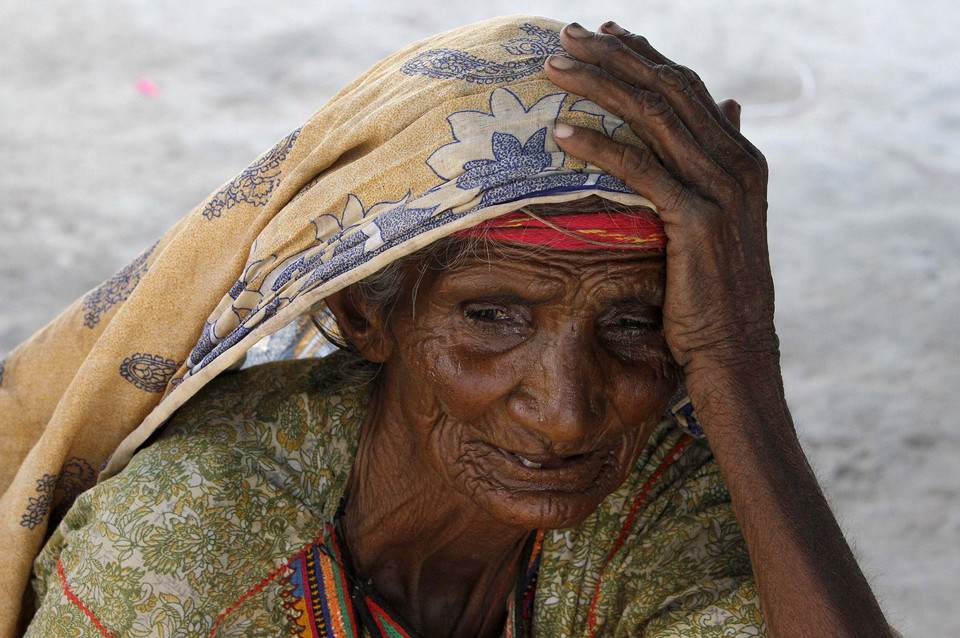 Bibi Nooran, who has been displaced by floods, takes refuge at a roadside makeshift camp for flood victims in Sujawal