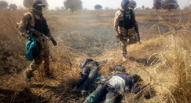 Nigerian soldiers stand over the corpses of neutralised Boko Haram terrorists [Facebook/HQ Nigerian Army]