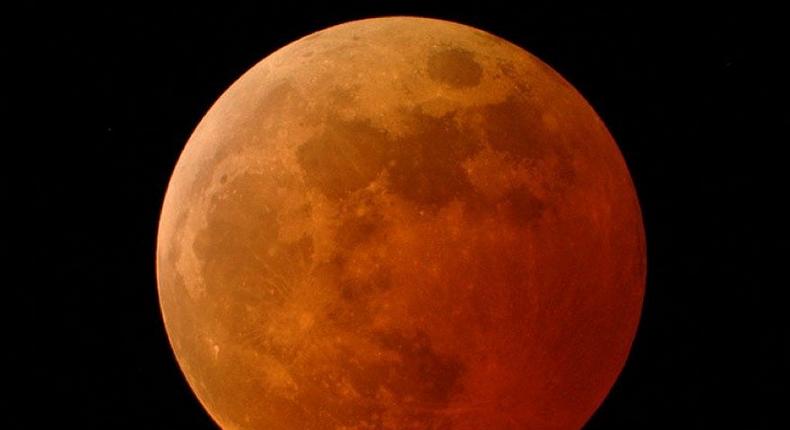 The moon appears orange-red in a total lunar eclipse on October 27, 2004.