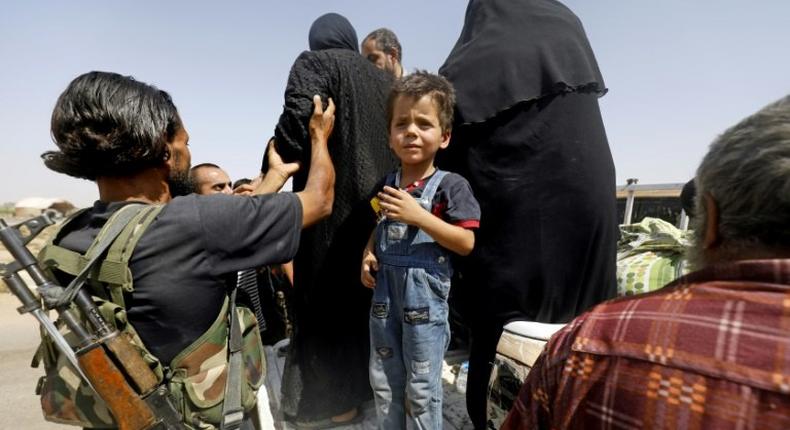 Displaced Syrians who fled from the Islamic State (IS) group's stronghold of Raqa arrive in the village of Hawi al-Hawa