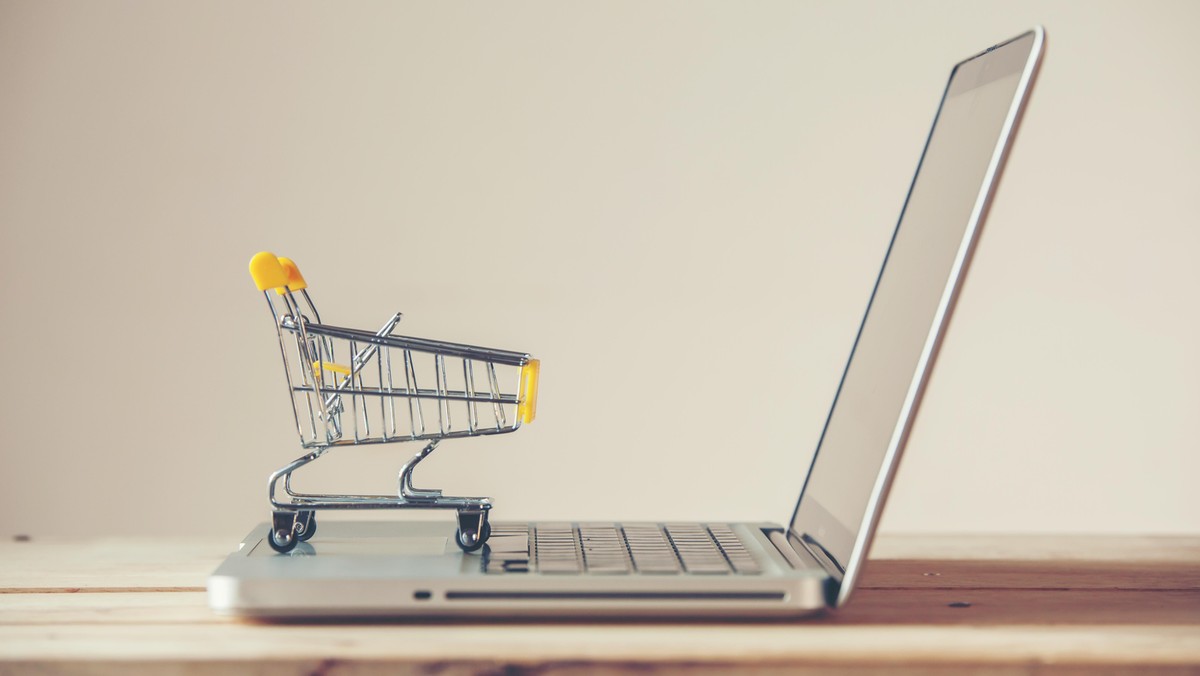 Small Shopping Cart On Laptop With Copyspace : Online Shopping Concept. E-commerce.