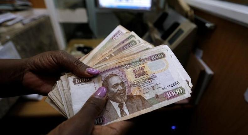 A teller counts Kenya shilling notes inside the cashier's booth at a forex exchange bureau in Kenya's capital Nairobi, April 20, 2016. REUTERS/Thomas Mukoya