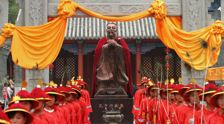 Hagyományos ruhába öltözött diákok állnak sorfalat Konfuciusz (Kr. e. 551-479) szobra előtt a kínai filozófus és tanító tiszteletére rendezett szertartás során a Csilin tartományban található Csangcsun konfuciánus templománál / Fotó: Getty Images