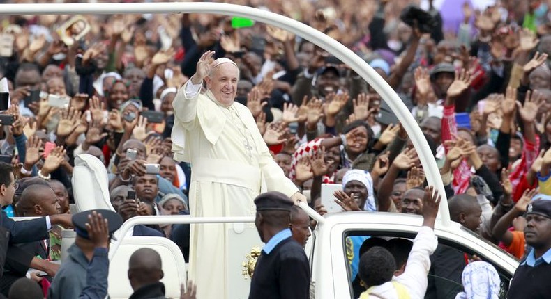 Pope Francis waves to faithful while riding in an open truck as he arrives for a Papal mass in Kenya's capital Nairobi, November 26, 2015. REUTERS/Thomas Mukoya