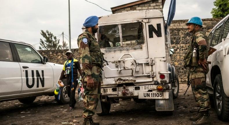 Indian Blue Helmet peacekeepers stand guard next to United Nations vehicles in Goma on November 8, 2016