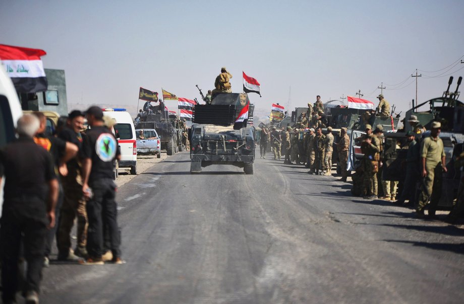 Members of Iraqi federal forces gather to continue to advance in military vehicles in Kirkuk.