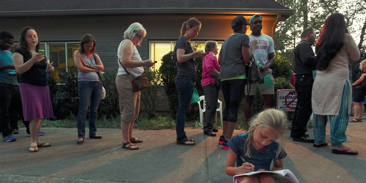 Louisa Weinard, 9, works on her homework while her mother waits in a line at a polling station open into the evening as early voting for the 2016 general elections begins in Durham, North Carolina, U.S., October 20, 2016.