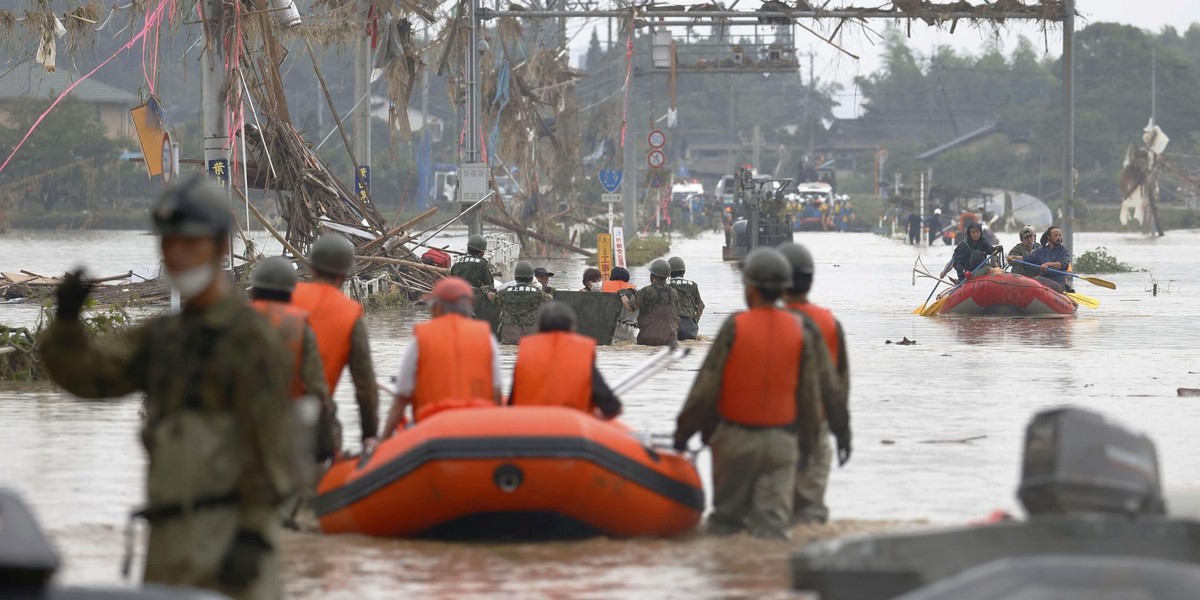 A car is pictured after it was drifted by torrential rain in Hitoyoshi