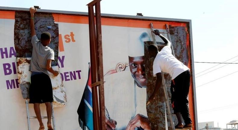 People tear a poster of former Gambian president Yaya Jammeh in Broussbi, Gambia, December 4, 2016. REUTERS/Thierry Gouegnon