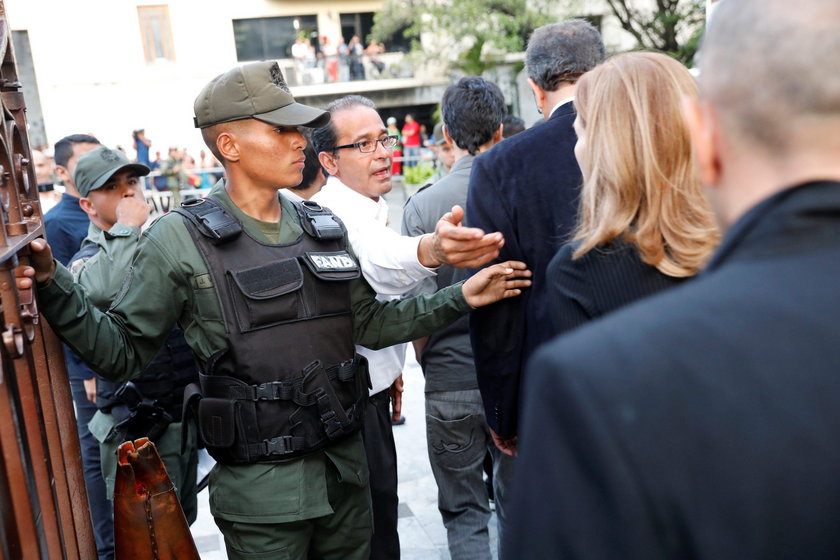 An injured government supporter is taken away by security forces after he and a group of fellow gove