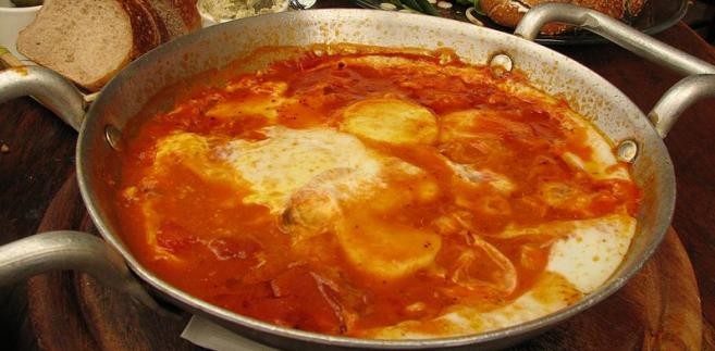 <b>Szakszuka</b><br />Bardzo popularna potrawa śniadaniowa: to smażone na oliwie pomidory z cebulą i przyprawami oraz wbijanym na samym końcu jajkiem. Z reguły podawane w żeliwnej patelni.