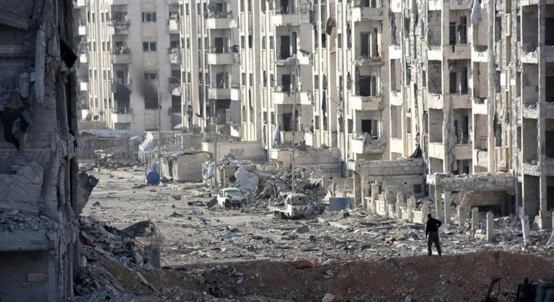 A person stands amid heavily damaged buildings in Aleppo's 1070 district on November 8, 2016, after troops seized it from rebel fighters