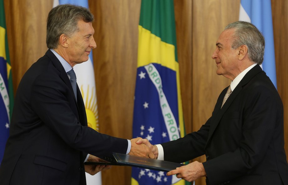 Argentine President Mauricio Macri, left, and his Brazilian counterpart, Michel Temer, exchange documents after a meeting at the Planalto Palace in Brasilia, Brazil, February 7, 2017.