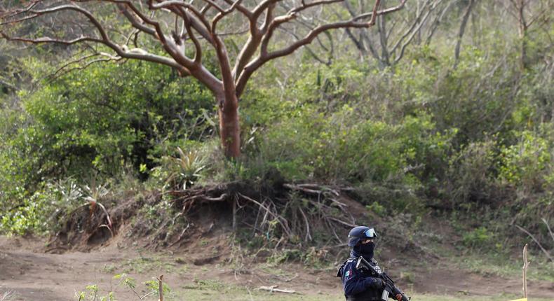 A policeman stands guard on a plot of land where skulls were found at unmarked graves on the outskirts of Veracruz, Mexico, March 16, 2017.