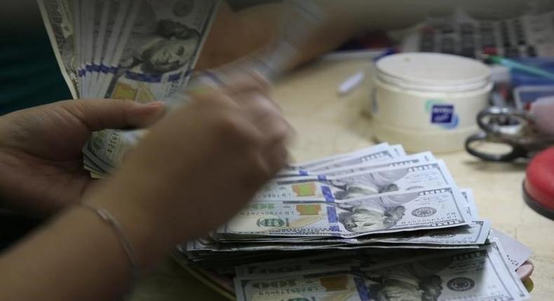 A worker counts U.S. 100-dollar banknotes inside a money changer in Manila, Philippines March 23, 2016. 