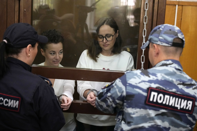Reżyserka teatralna Żenia Berkowicz (po lewej) i dramatopisarka Swietłana Petrijczuk stoją w szklanej klatce na sali sądowej przed rozprawą w sądzie w Moskwie, Rosja, 6 września 2023 r.