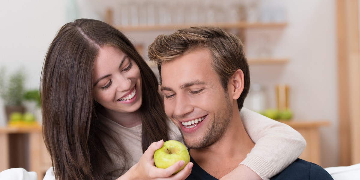 mdchen hlt ihrem freund einen apfel vor die nase