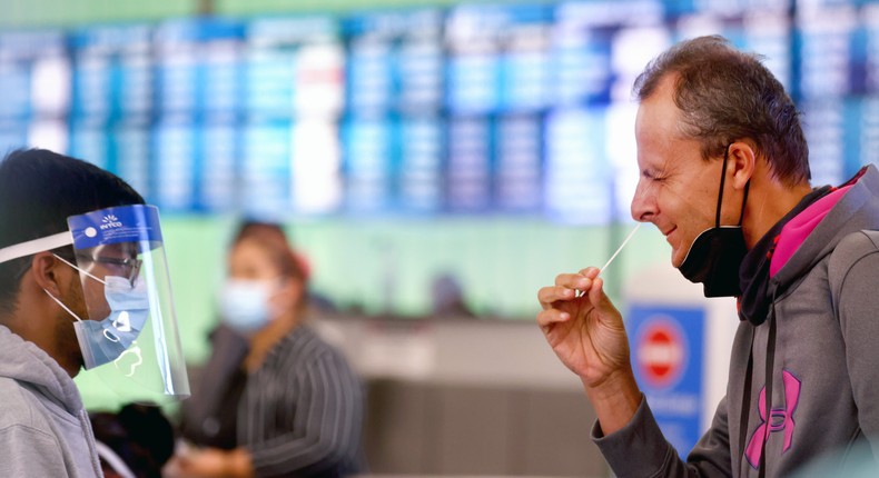 A passenger who arrived from Italy administers a self-collected nasal swab at Los Angeles International Airport on December 3, 2021.