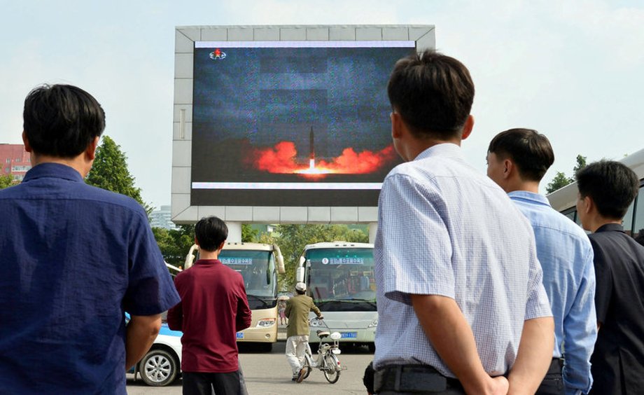 North Koreans watch a news report showing the Hwasong-12 intermediate-range ballistic missile launch, in Pyongyang, in this photo taken by Kyodo, August 30, 2017.