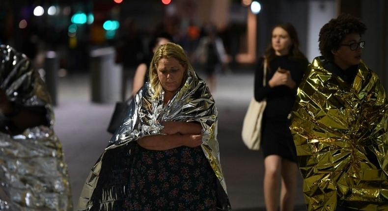 Members of the public, wrapped in emergency blankets, leave the scene of the terror attack on London Bridge in central London on June 3