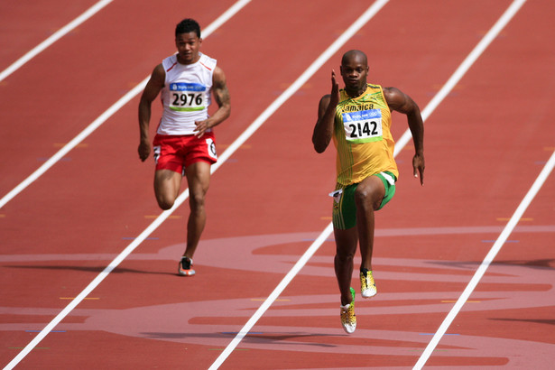 Asafa Powell z Jamajki oraz Aisea Tohi z Tonga walczą o zwycięstwo podczas jednej z rund biegu na 100 metrów na Igrzyskach w Pekinie. Fot. Bloomberg