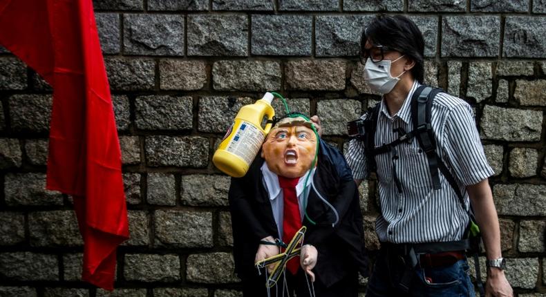 A pro-China activist holds an effigy of President Donald Trump outside the US consulate in Hong Kong in May 2020 after he announced restrictions on Chinese students