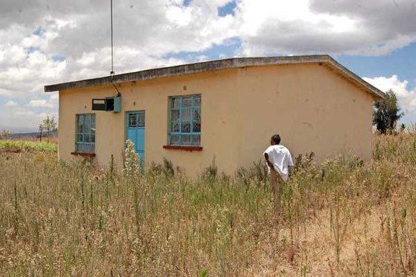 Damaris Wambui Kamau standing next to the house she rejected at Murunyu in Bahati Nakuru North, terming it substandard and not the gift from President Kenyatta 