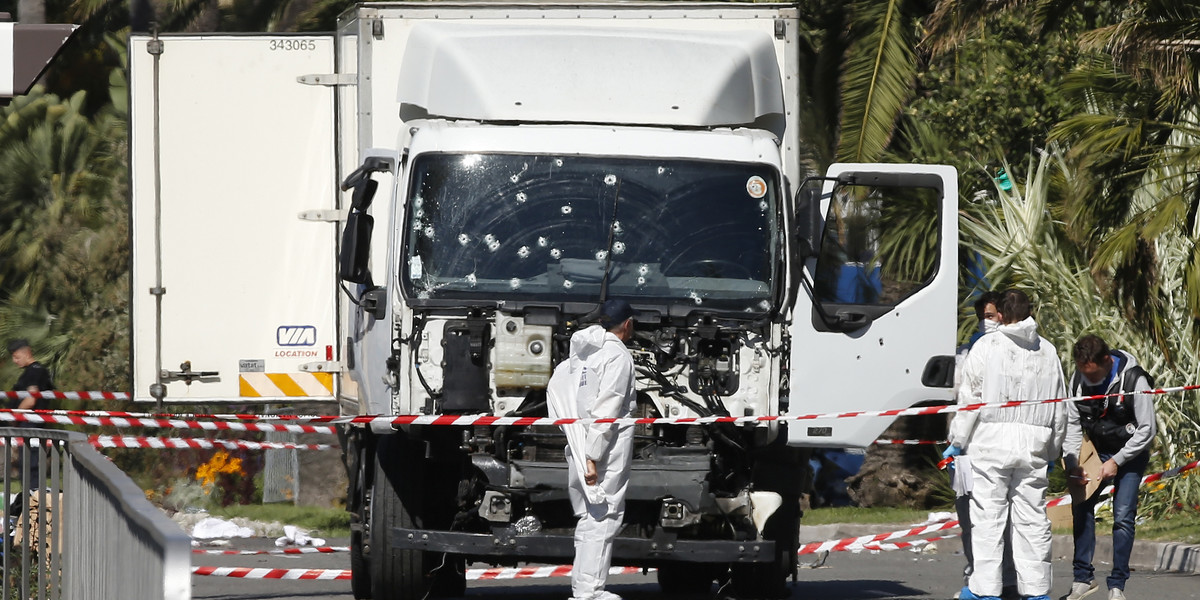 Investigators work at the scene near the truck that ran into a crowd at high speed killing scores who were celebrating Bastille Day in Nice.