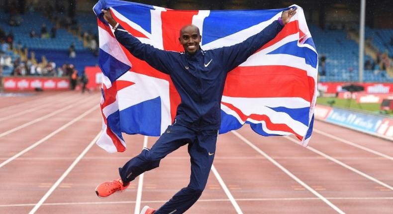 Britain's Mo Farah poses with a national flag after winning the men's 3,000m during the 2017 IAAF Birmingham Diamond League athletics on August 20, 2017