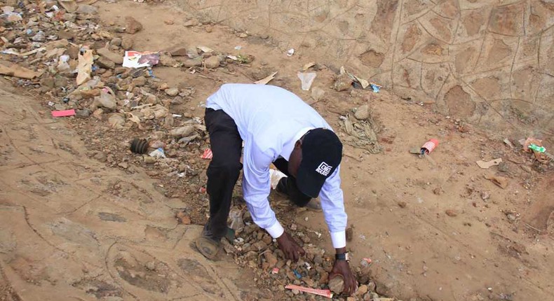 Former Kakamega Senator Boni Khalwale picking stones during Kibra by-election. Kenyans angry after Khawale's circumcision comment against Kibra residents