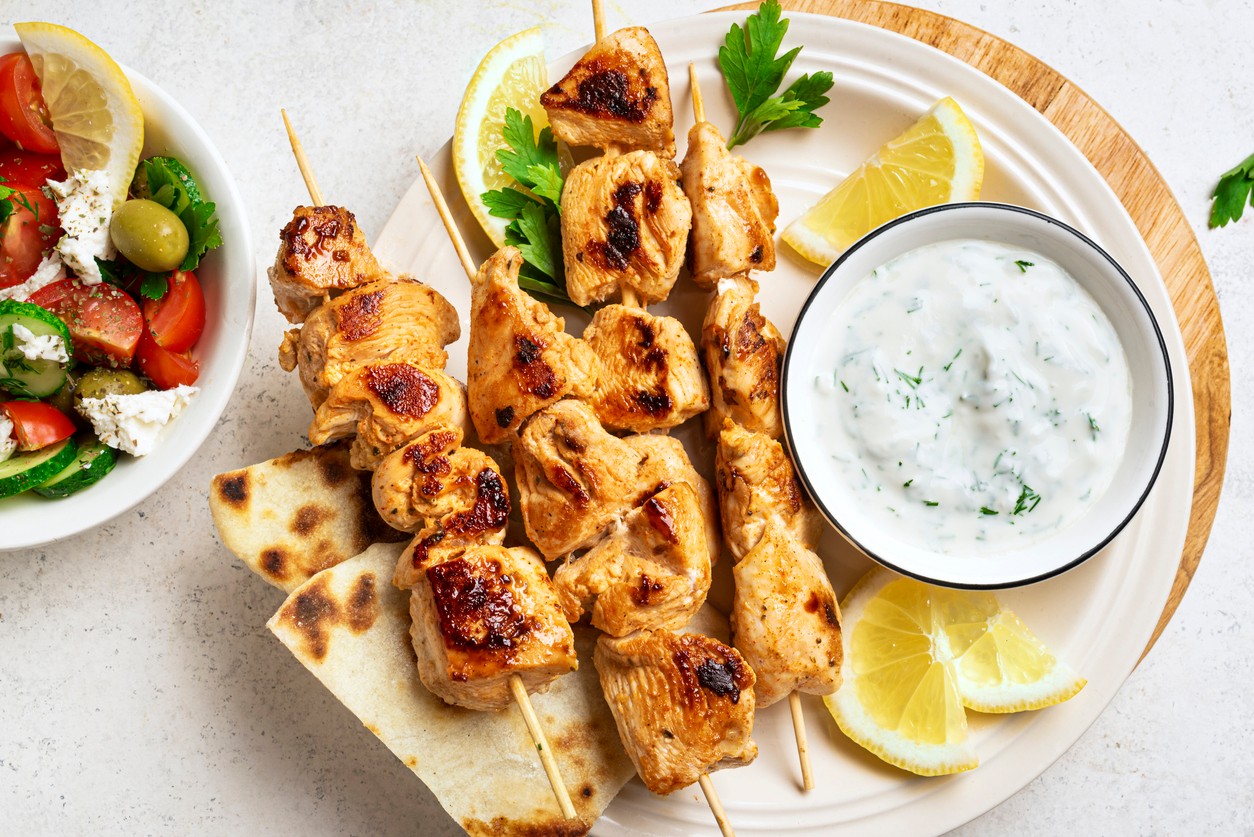 Tzatziki podávané s grilovaným kuracím mäsom a pitou v stredomorskom štýle.