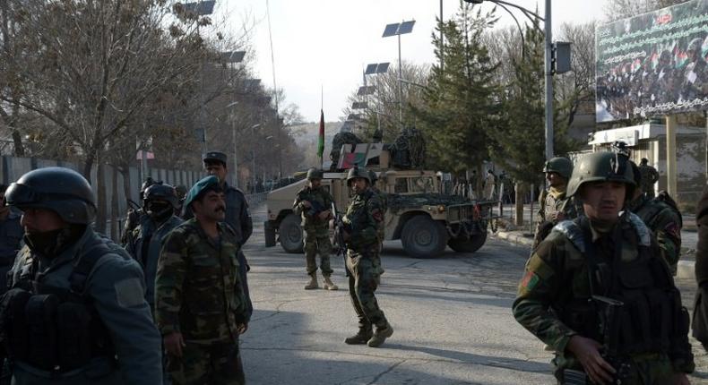 Afghan security personnel stand guard in front of the main gate of a military hospital in Kabul on March 8, 2017, after a deadly attack