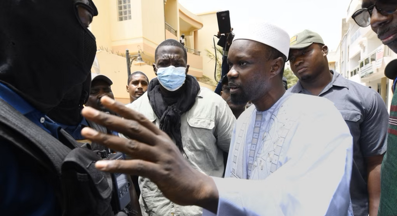 L'opposant sénégalais Ousmane Sonko discute avec des membres de la police devant sa résidence à Dakar, le 17 juin 2022.