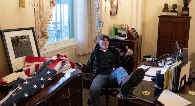 A supporter of President Donald Trump sits in the office of House Speaker Nancy Pelosi inside the US Capitol on January 6.