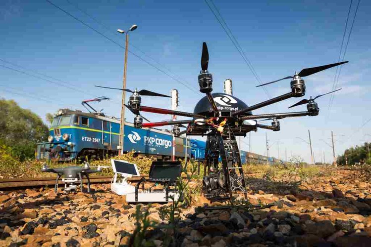 Na świecie drony znajdują zastosowanie w wojsku, fotografii i dostarczaniu przesyłek, ale zaczynają być także wykorzystywane w sektorze kolejowym. W USA Federalna Administracja Lotnictwa FAA wiosną tego roku udzieliła pierwszego pozwolenia przewoźnikowi kolejowemu na wykorzystywanie dronów do inspekcji torów.  <br><br> Na zdjęciu: Oba drony ze sprzętem filmującym i do sterowania