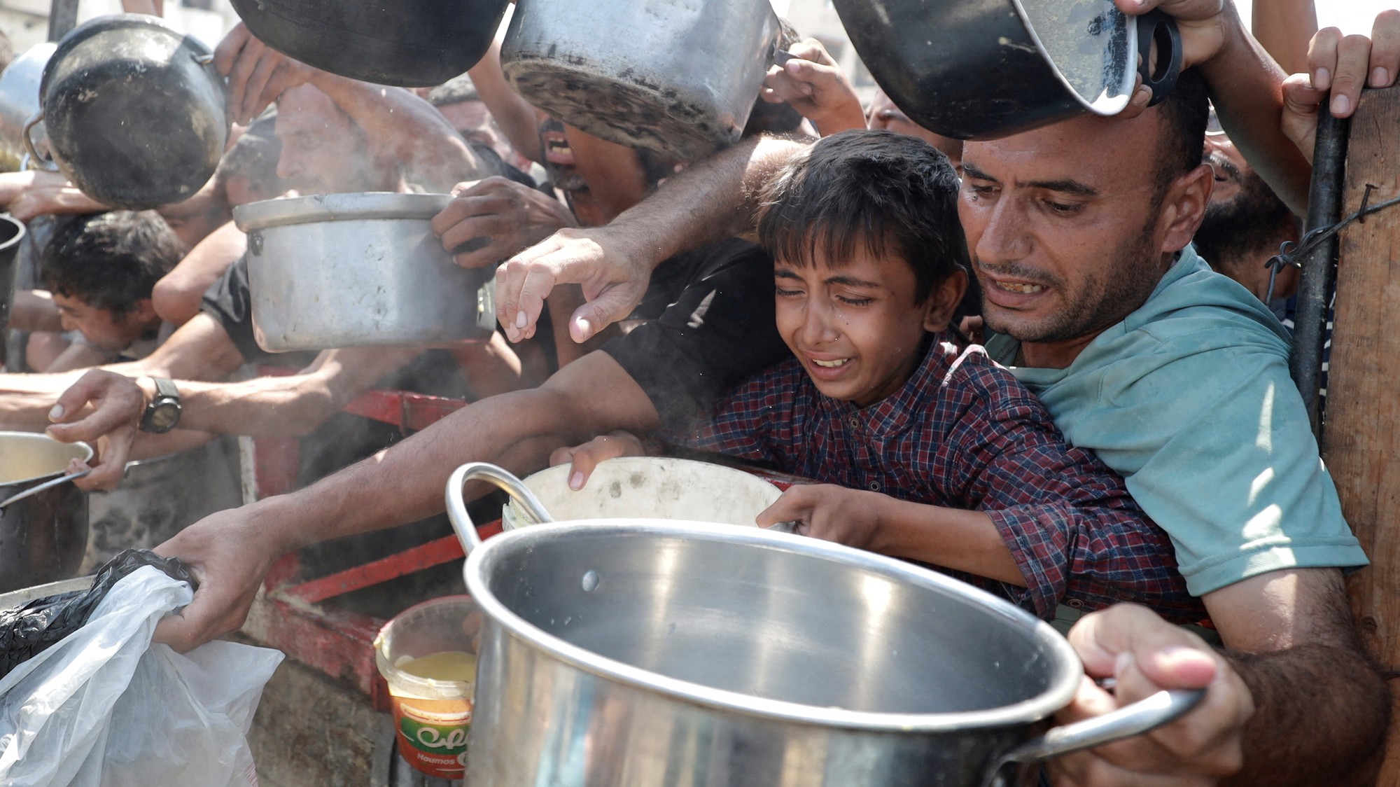 Palestínčania čakajú na jedlo z charitatívnej kuchyne v meste Gaza, REUTERS/Khamis Al-Rifi
