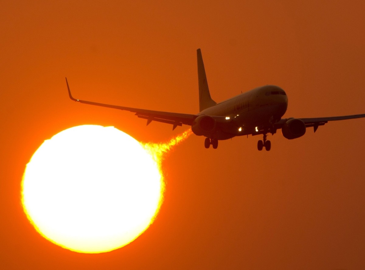 Startujący boeing 737 na tle słońca