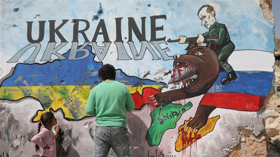 Sirijski umetnik slika grafit u znak solidarnosti sa Ukrajinom na zgradi koju su srušili Rusi u Idlibu 11. aprila 2022.
