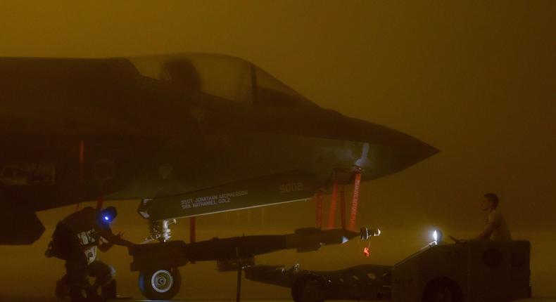 Airmen load a bomb into the F-35A's internal bomb bay.