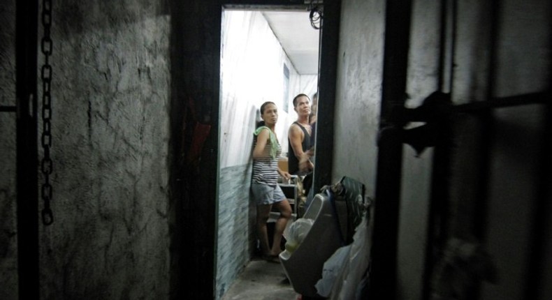 A dozen people have been found stuffed inside a closet-sized cell hidden behind a book shelf in a Philippine police station