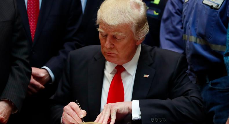 President Donald Trump signs H.J. Res. 38 in the Roosevelt Room of the White House in Washington, Thursday, Feb. 16, 2017.