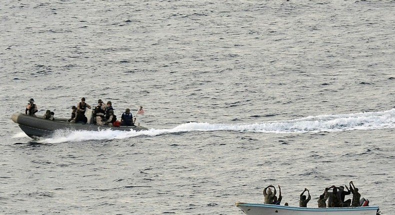 Search and seizure team members (L) from the USS Vella Gulf close in to apprehend suspected pirates (R) in the Gulf of Aden in 2009