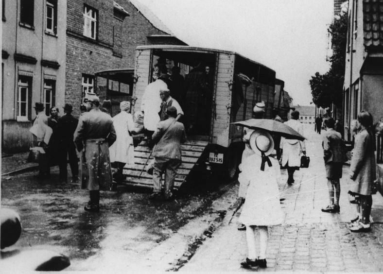 Przechodnie widzą, jak policja ładuje Żydów na ciężarówki w celu deportacji. Kerpen, Nadrenia Północna-Westfalia, 1942 r. 
