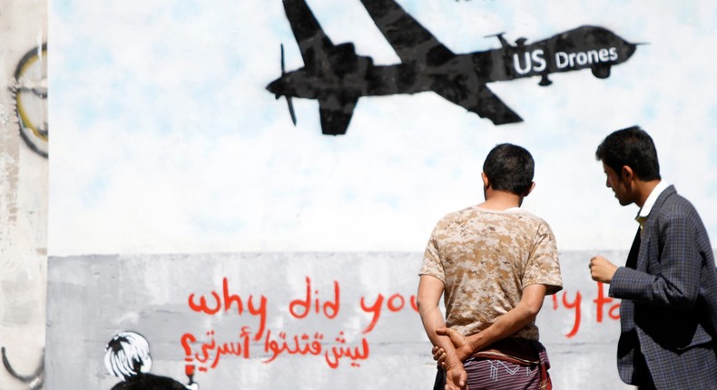 Men look at wall graffiti depicting a U.S. drone along a street in Sanaa, Yemen, November 9, 2013. 
